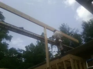 Carpenter setting a ridge beam over a new addition frame — Ice Dam Removal by Roofing Brothers in Montclair