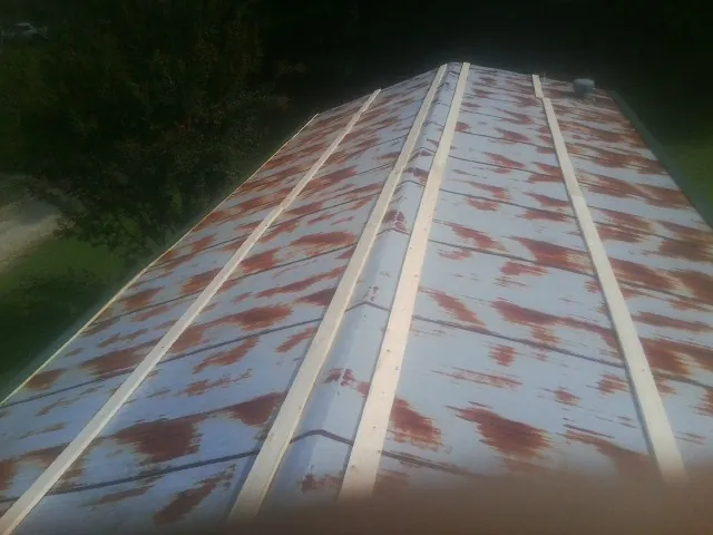 Rusted metal roof panels with new wood purlins before replacement — Storm Damage Roof Repair in Montclair by Roofing Brothers